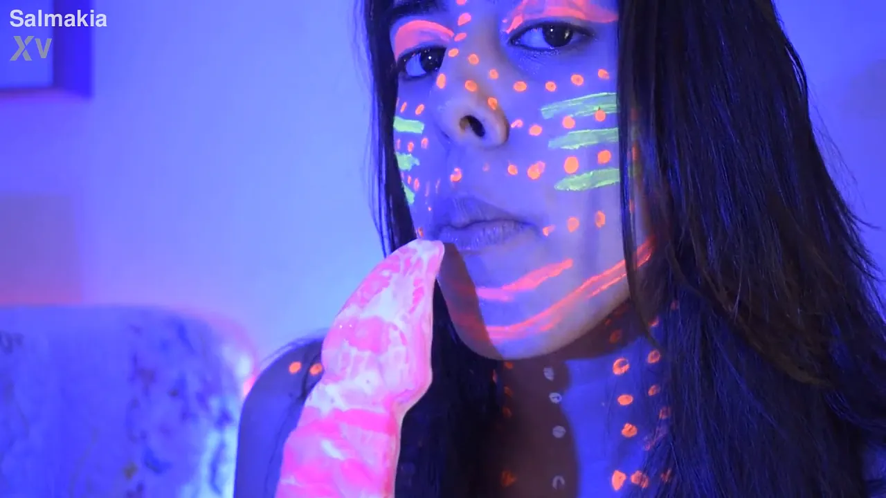 Girl sucks and licks a huge pink dildo in a neon-lit toyshop